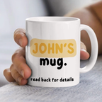 White mug with 'JOHN'S mug. read back for details' text held by a hand.