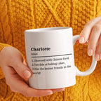 Person holding a white mug with text against an orange textured background