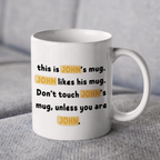 White mug with text 'this is JOHN's mug. JOHN likes his mug. Don't touch JOHN's mug, unless you are JOHN.' on a gray surface.