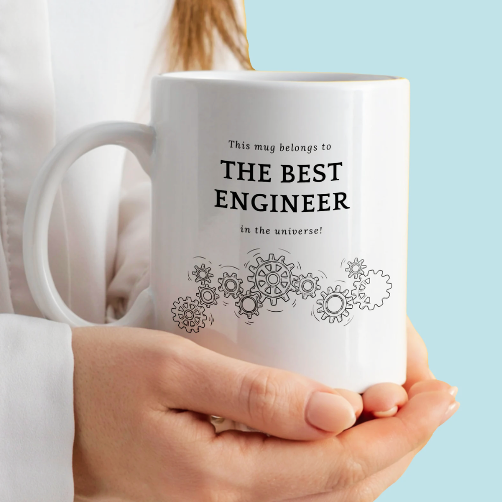 White mug with text and gear designs held by a person against a light blue background
