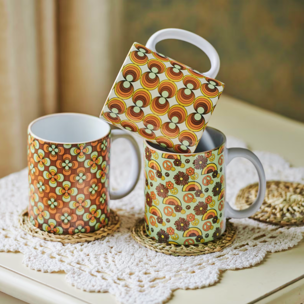 Three patterned mugs on a lace doily with a blurred background