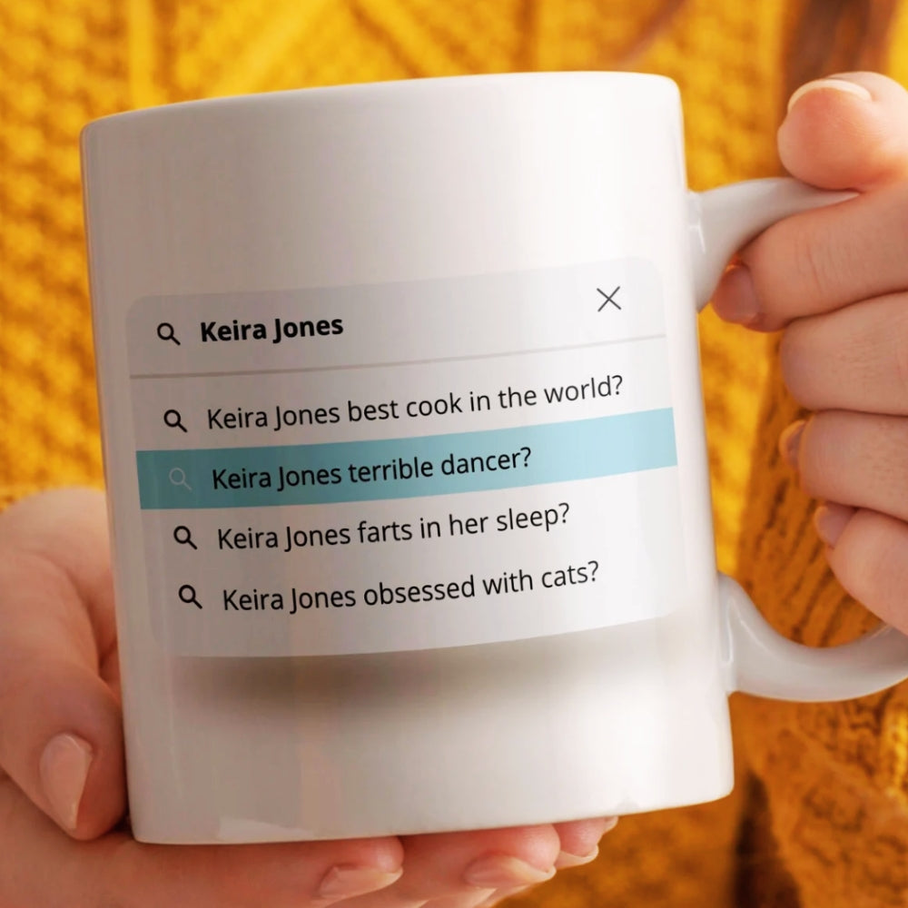 Person holding a mug with a humorous search bar graphic on it.