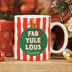 Christmas-themed mug with 'FAB YULE LOUS' text and decorative elements on a festive background.