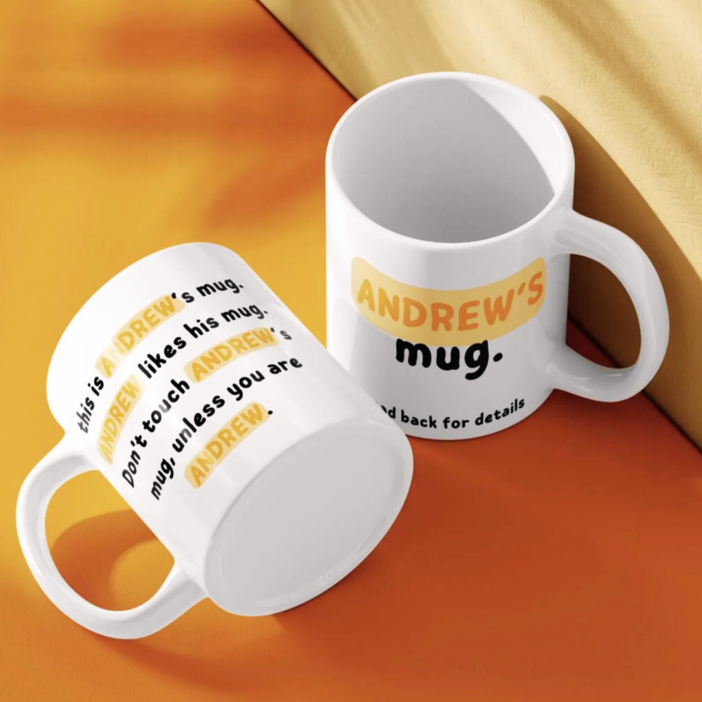 Two white mugs with personalized text on a yellow and orange background