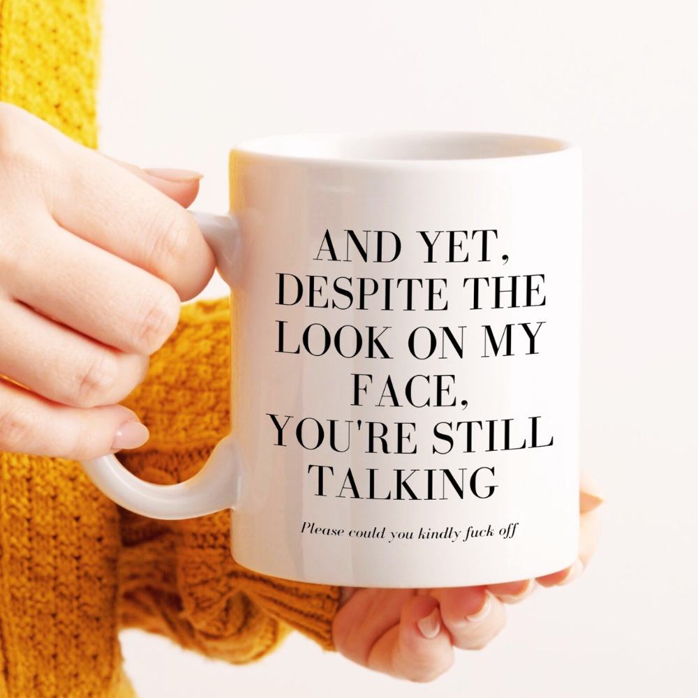 Person holding a mug with humorous text on a white background