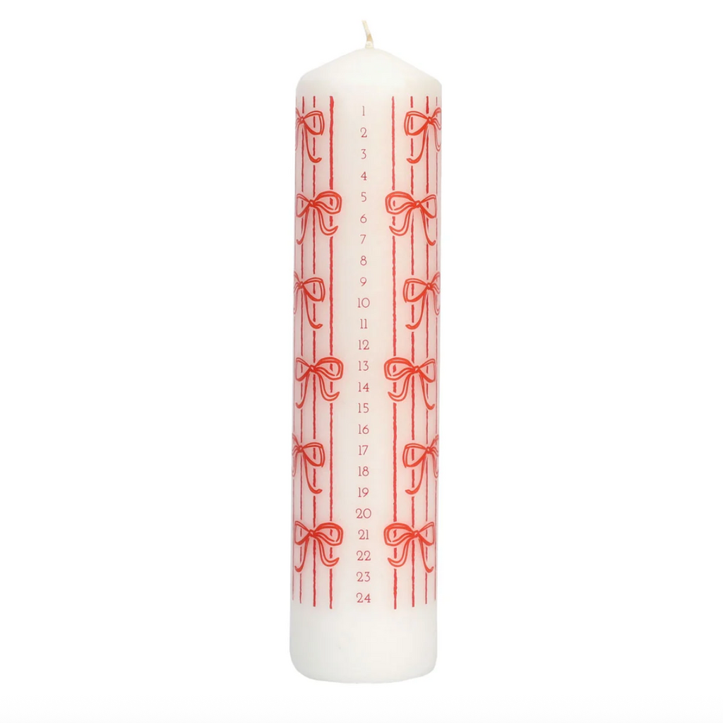 A white advent candle with red vertical stripes, red bows, and numbered days from 1 to 24 printed vertically, shown on a plain white background.
