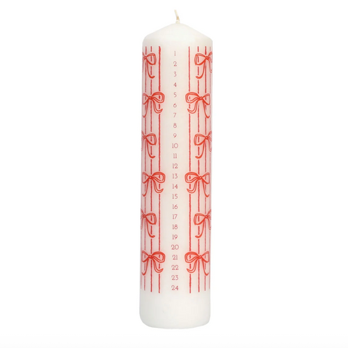 A white advent candle with red vertical stripes, red bows, and numbered days from 1 to 24 printed vertically, shown on a plain white background.