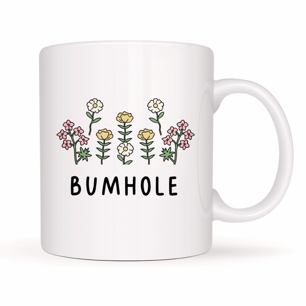 White mug with floral design and 'BUMHOLE' text on a white background