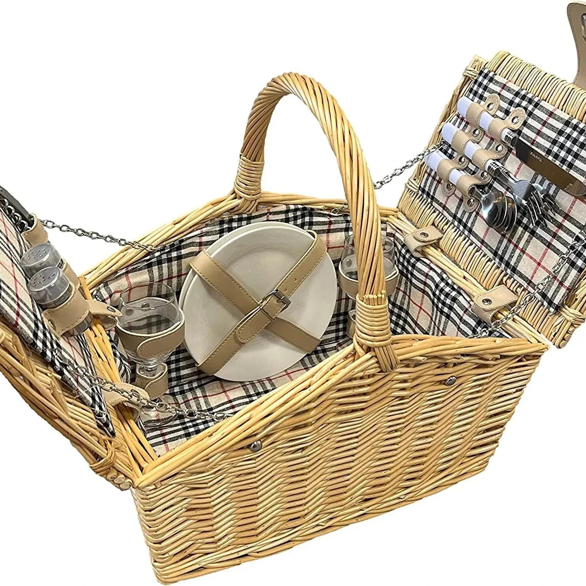 A classic wicker picnic basket with a beige and black plaid fabric lining, shown open to display its contents, including a white plate with a beige strap, metal canisters, and a picnic blanket on a white background.