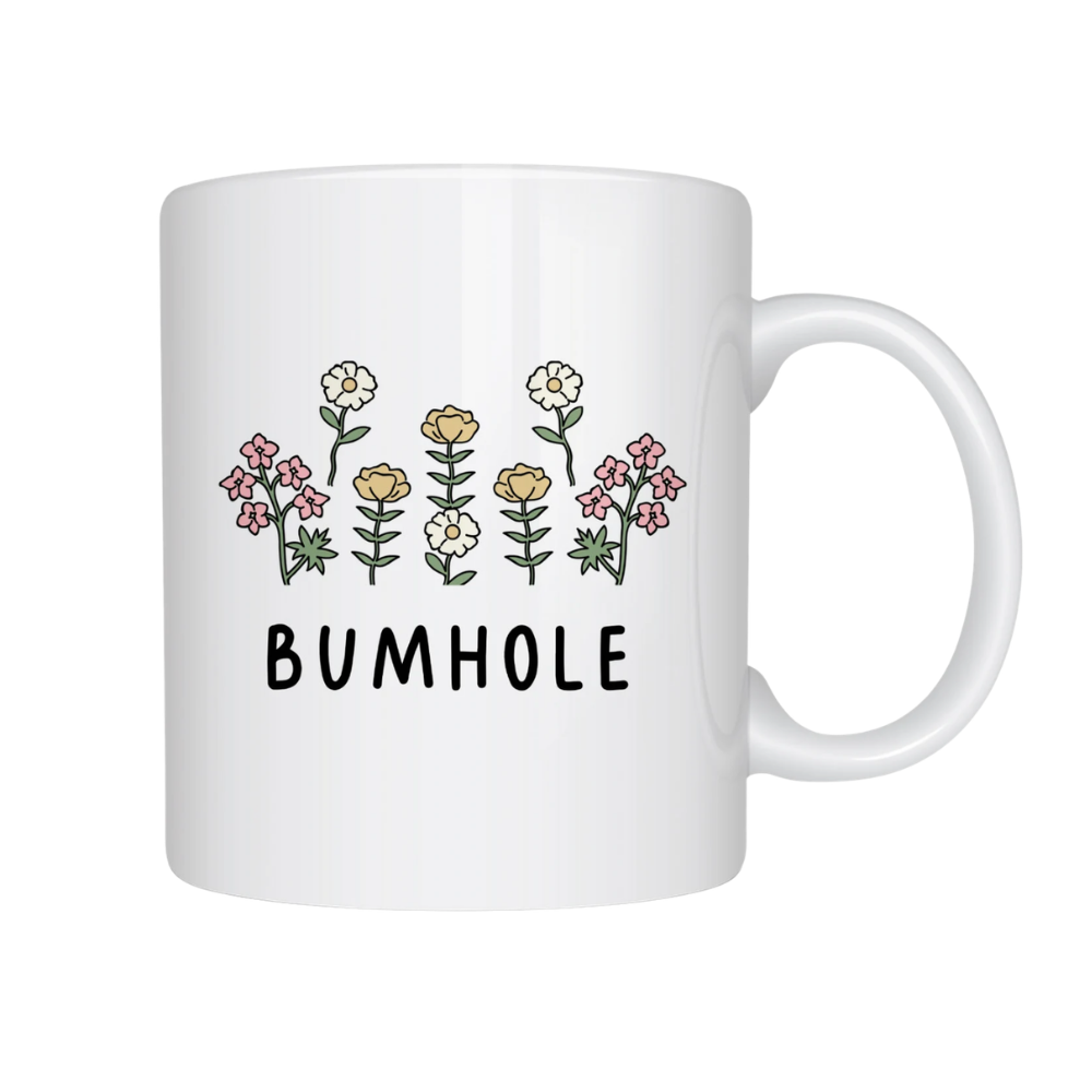 White mug with floral designs and the word 'BUMHOLE' on a white background