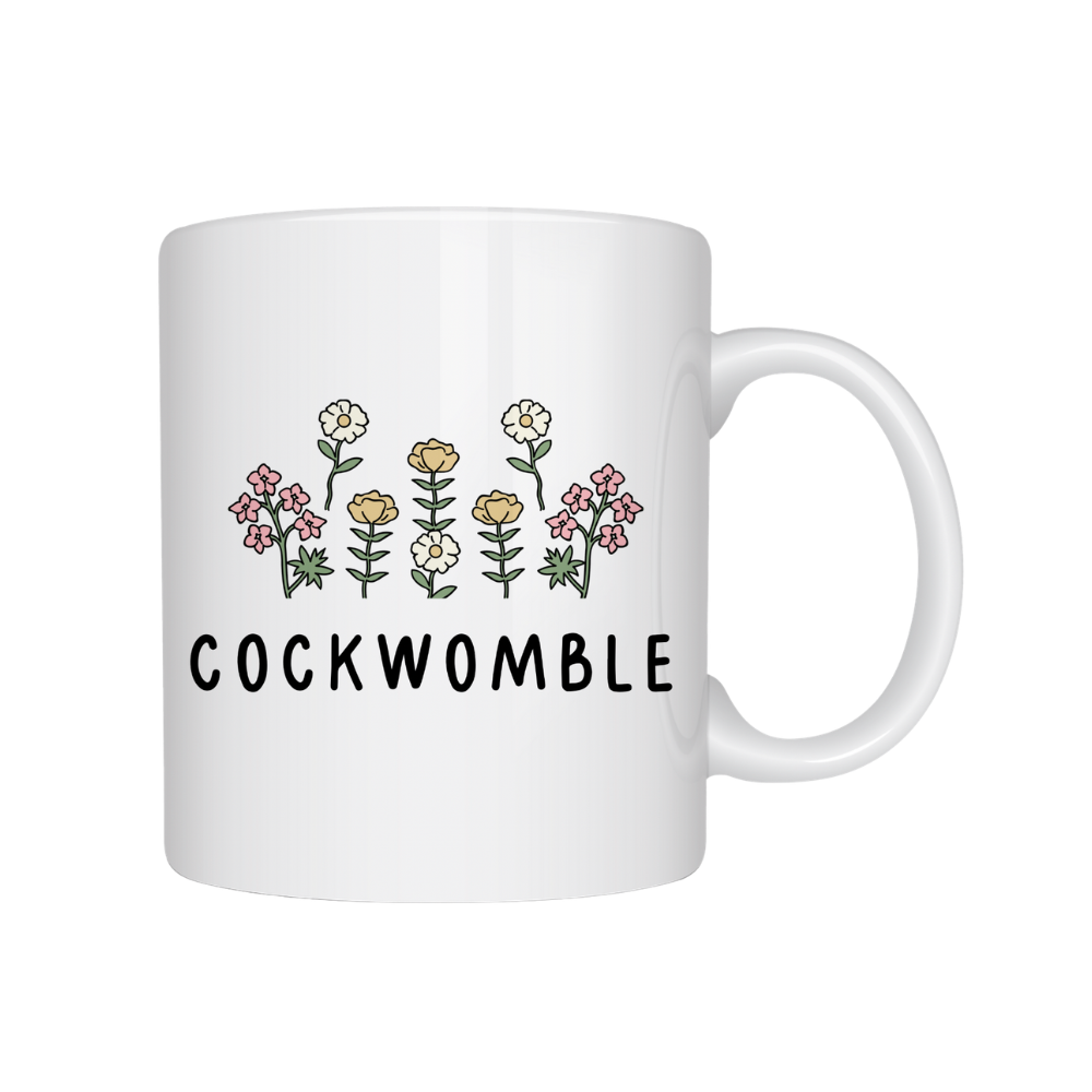 White mug with floral design and 'COCKWOMBLE' text on a white background