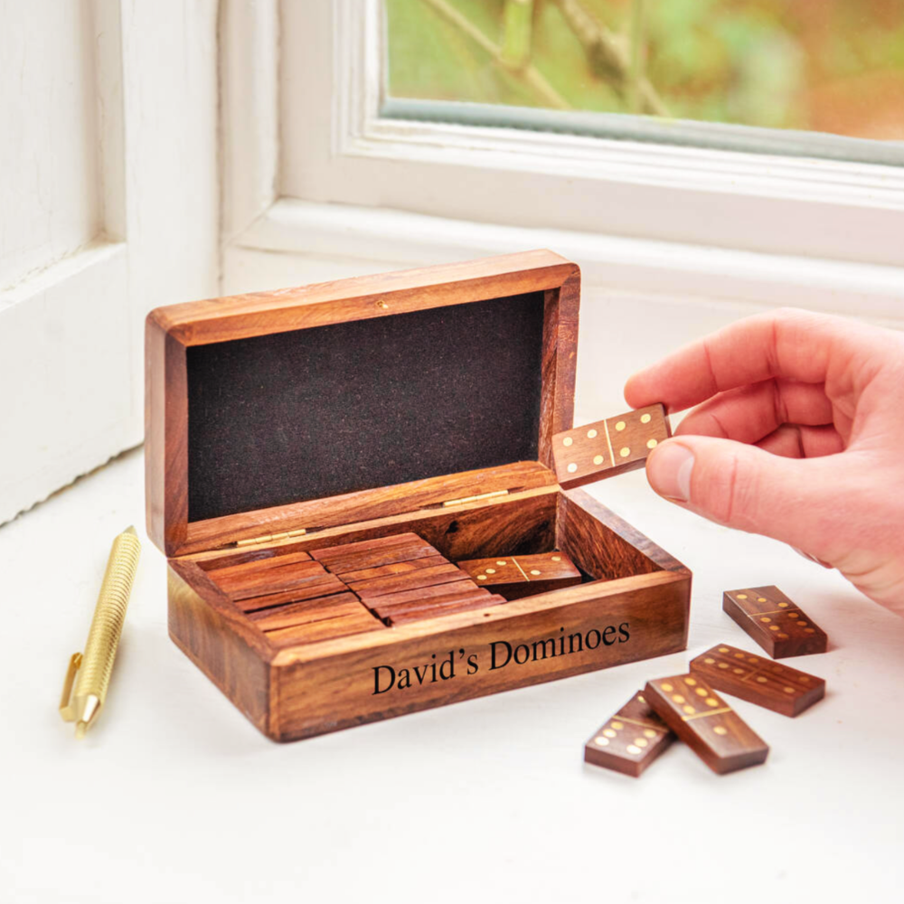 Wooden domino set with 'David's Dominoes' branding on a light surface.