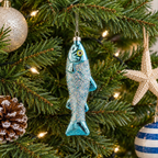 Personalised Sardine Christmas Bauble hanging on a Christmas tree showing the full iridescent glitter sardine glass decoration with silver hanging loop and personalised wooden tag