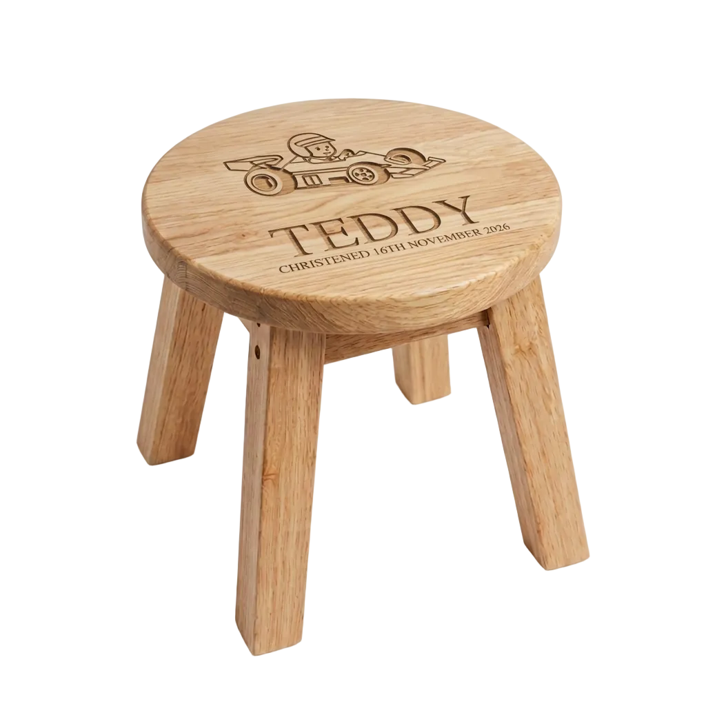Personalised Racing Car Wooden Stool styled in a nursery setting on a cream rug with name Teddy and christening date engraved on the round seat top