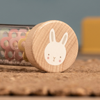 Child holding a personalised wooden bunny rainmaker sensory toy
