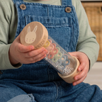 Child exploring a personalised wooden bunny rainmaker with colourful shapes and beads