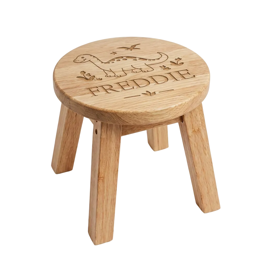 A small round wooden stool with four legs, featuring a personalized engraving of a dinosaur and the name 'FREDDIE' on the seat, shown on a white background.