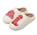 A pair of fluffy white sherpa slip-on slippers with red embroidered cartoon-style graphics on the top, shown on a clean white background.
