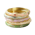 A stack of five traditional Indian bangles (jhumka bracelets) in pastel pink, lavender, cream, and green, each decorated with gold floral patterns and small colored stone accents, set against a plain white background.