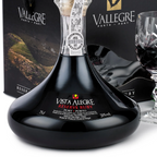 Vista Alegre Reserve Port wine bottle with its black presentation box and a crystal glass of dark red wine, shown on a white background with a grape garnish.