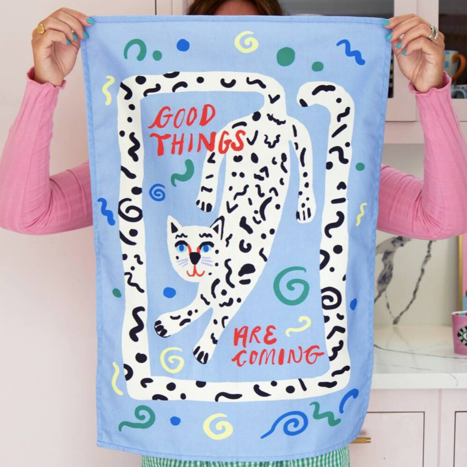Good Things Are Coming Tea Towel on pink background showing the full design and colours