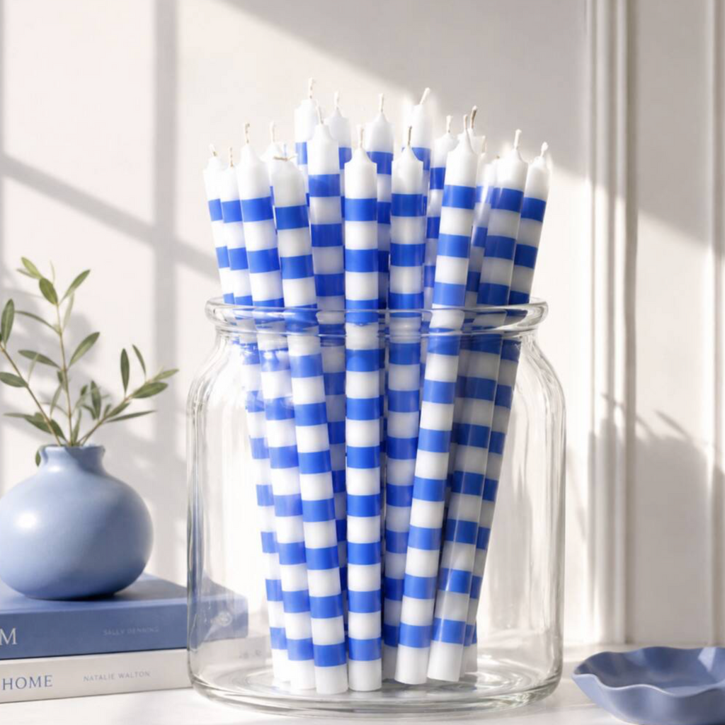 Blue and White Stripe Dinner Candles lit in blue glass candlestick holders on a formal dinner table