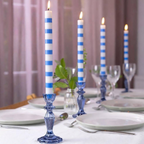 Blue and White Stripe Dinner Candles stored in a glass jar on a white shelf with blue vase and books