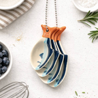 Sardine Ceramic Measuring Spoons stacked and hanging on silver ball chain on white background