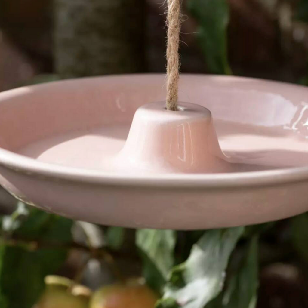 Close up of the cornflower blue Ceramic Hanging Bird Feeder and Bath suspended by jute rope showing the central cone detail
