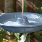 Close up of the blush pink Ceramic Hanging Bird Feeder and Bath suspended by jute rope showing the central cone and gloss glaze