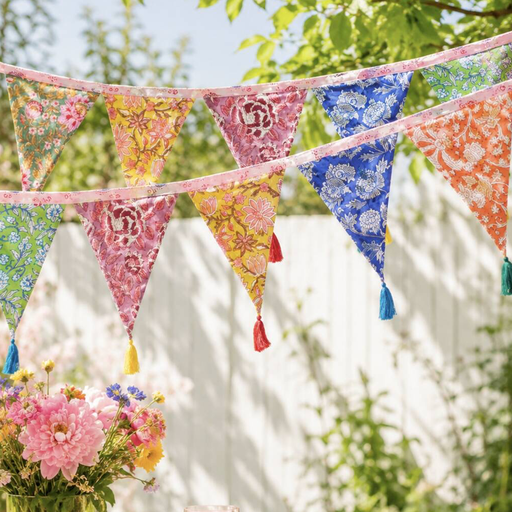 Hand Block Print Bunting With Tassels hung across a window showing the full range of floral block print flags and colourful tassels
