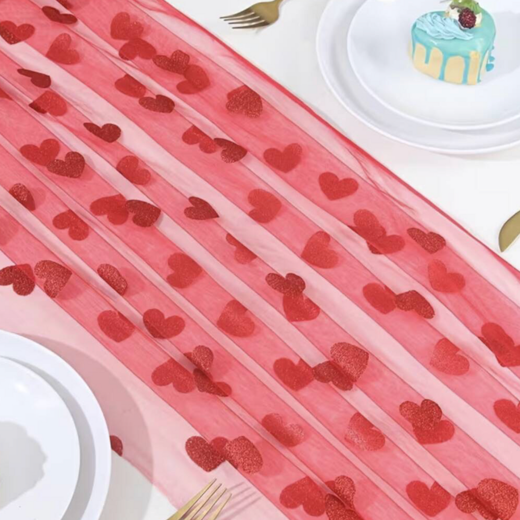 Embroidered Lace Hearts Table Runner draped along a wooden dining table with white lace doilies cutlery and a glass vase