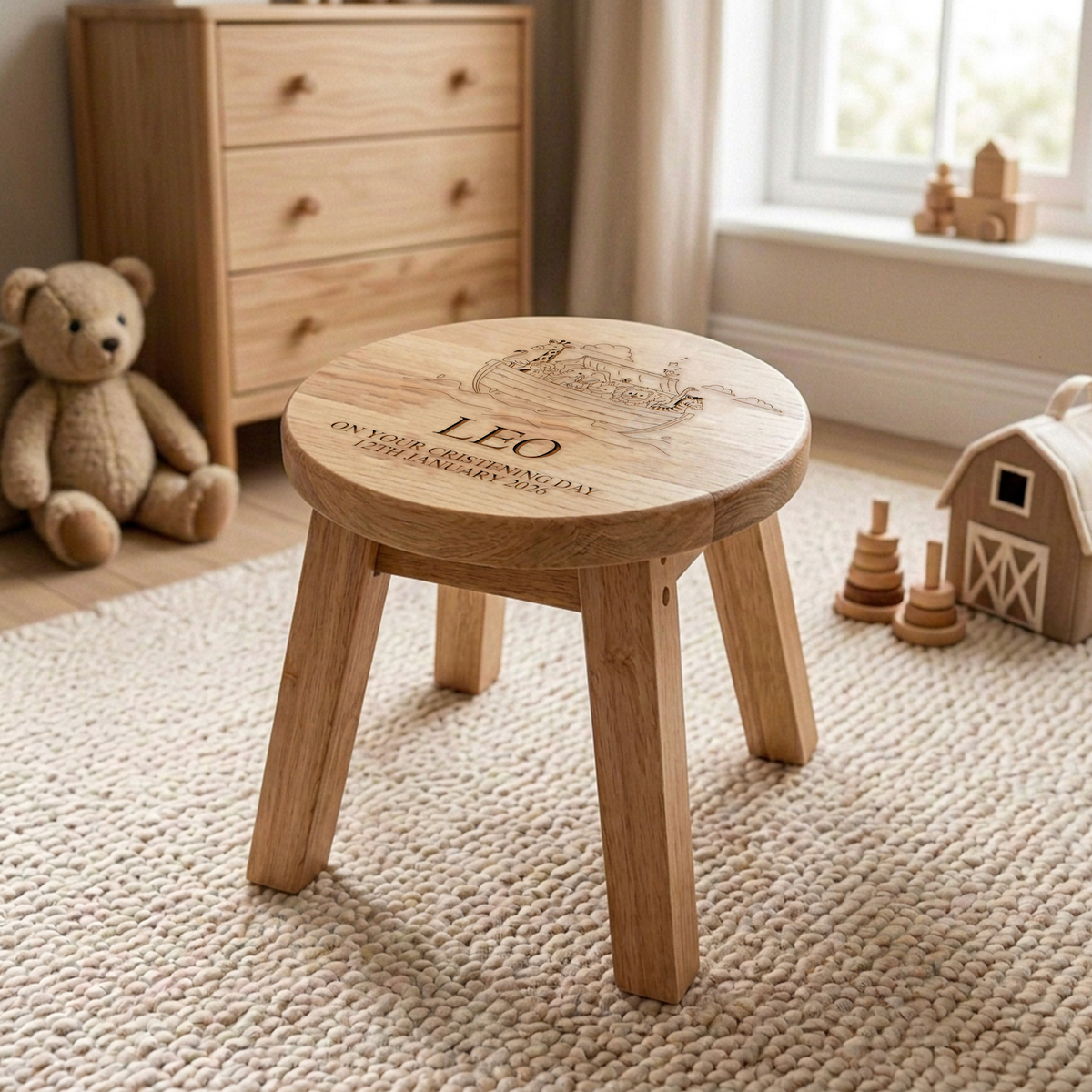 Personalised Noah's Ark Wooden Stool with name Freddie styled in a nursery setting on a cream rug beside wooden toys and a teddy bear