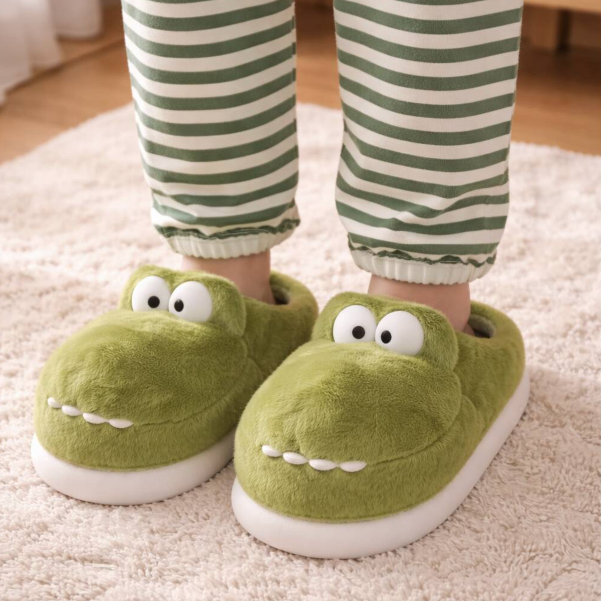 Close-up pair of fluffy green monster slippers with cartoon eyes and teeth
