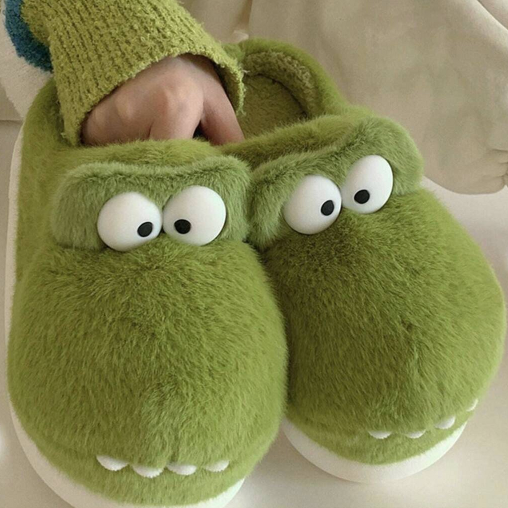 Green monster slippers with 3D eyes and teeth being worn at home