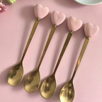 Gold heart-handle spoons displayed in a jar for serving drinks or desserts