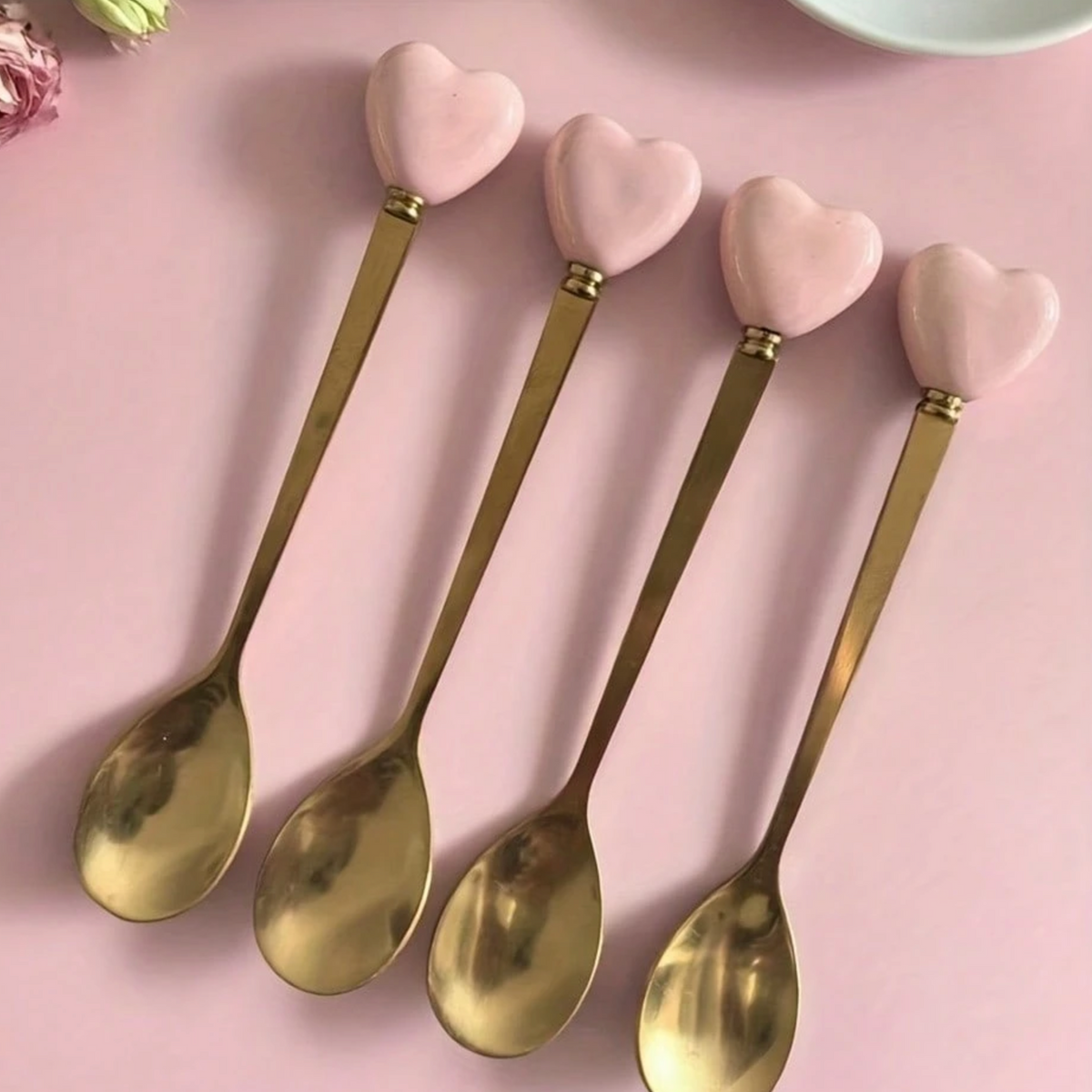 Gold heart-handle spoons displayed in a jar for serving drinks or desserts