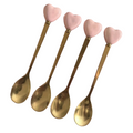 Close-up of gold heart-handle spoons with decorative pink heart handles