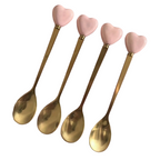 Close-up of gold heart-handle spoons with decorative pink heart handles