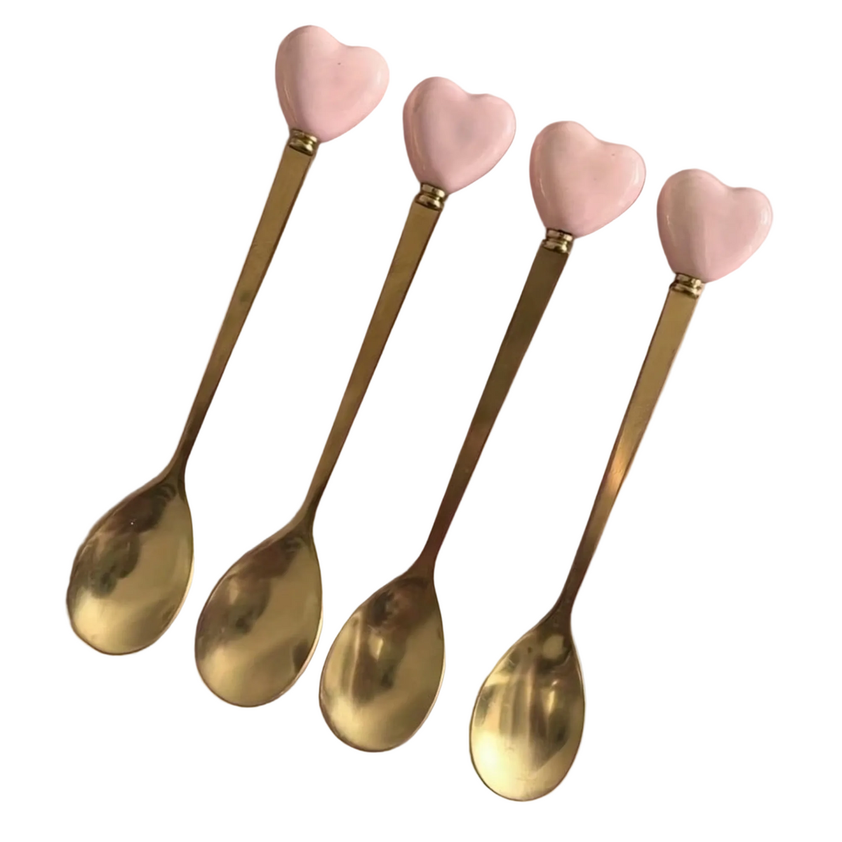 Close-up of gold heart-handle spoons with decorative pink heart handles
