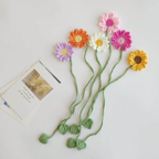 Yellow crochet sunflower bookmark tied around a white curtain as a decorative accessory
