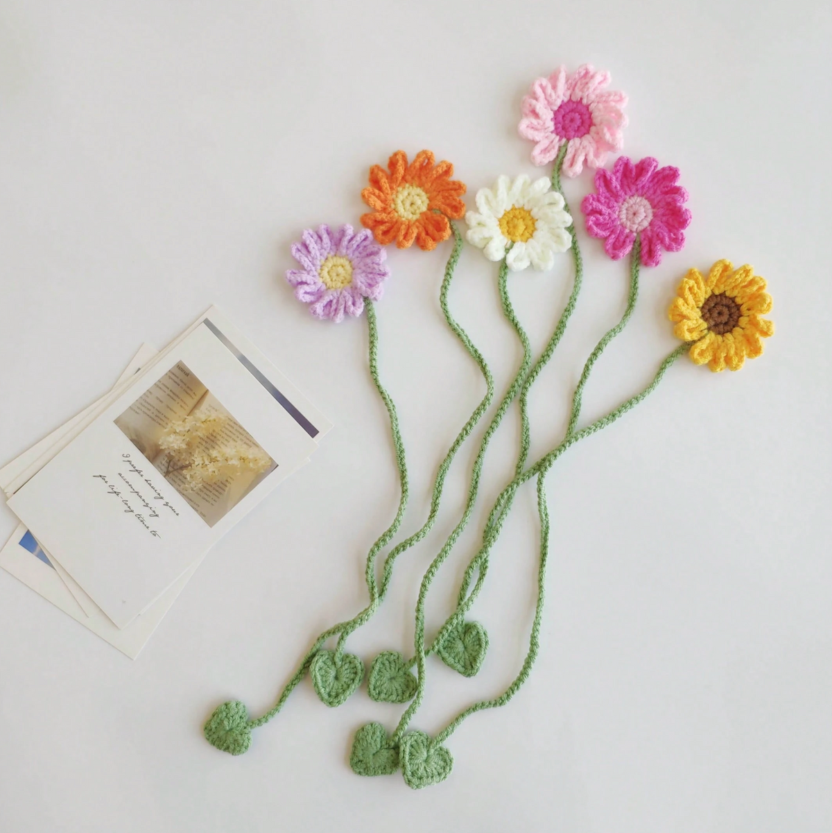 Yellow crochet sunflower bookmark tied around a white curtain as a decorative accessory