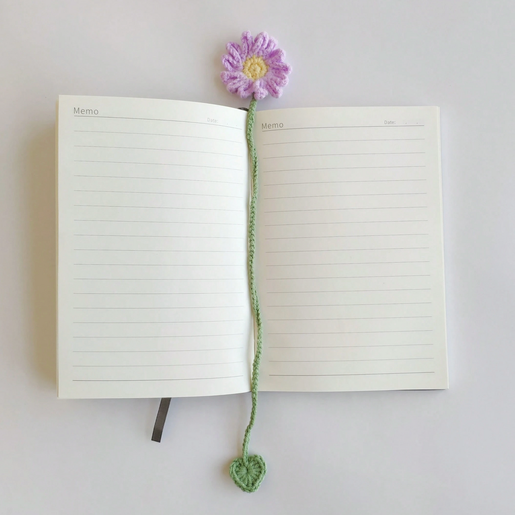 A selection of six colourful crochet flower bookmarks arranged beside a book