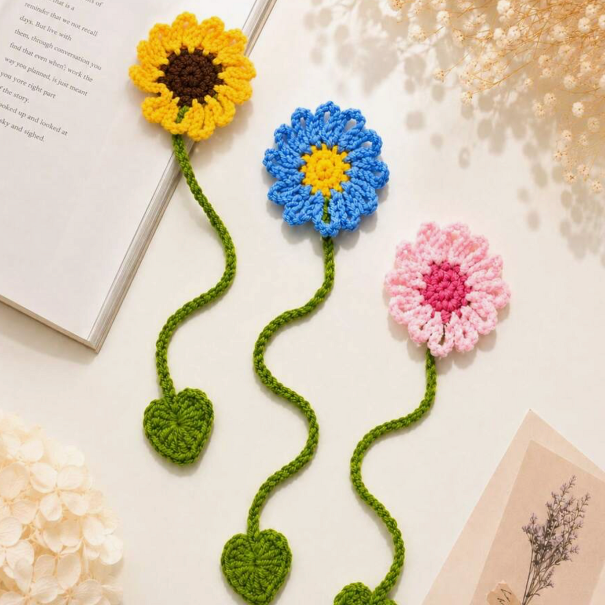 Hand holding a yellow crochet sunflower bookmark over an open book