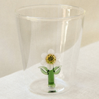 Two clear glass tumblers with a glass flower inside, on a wooden garden table