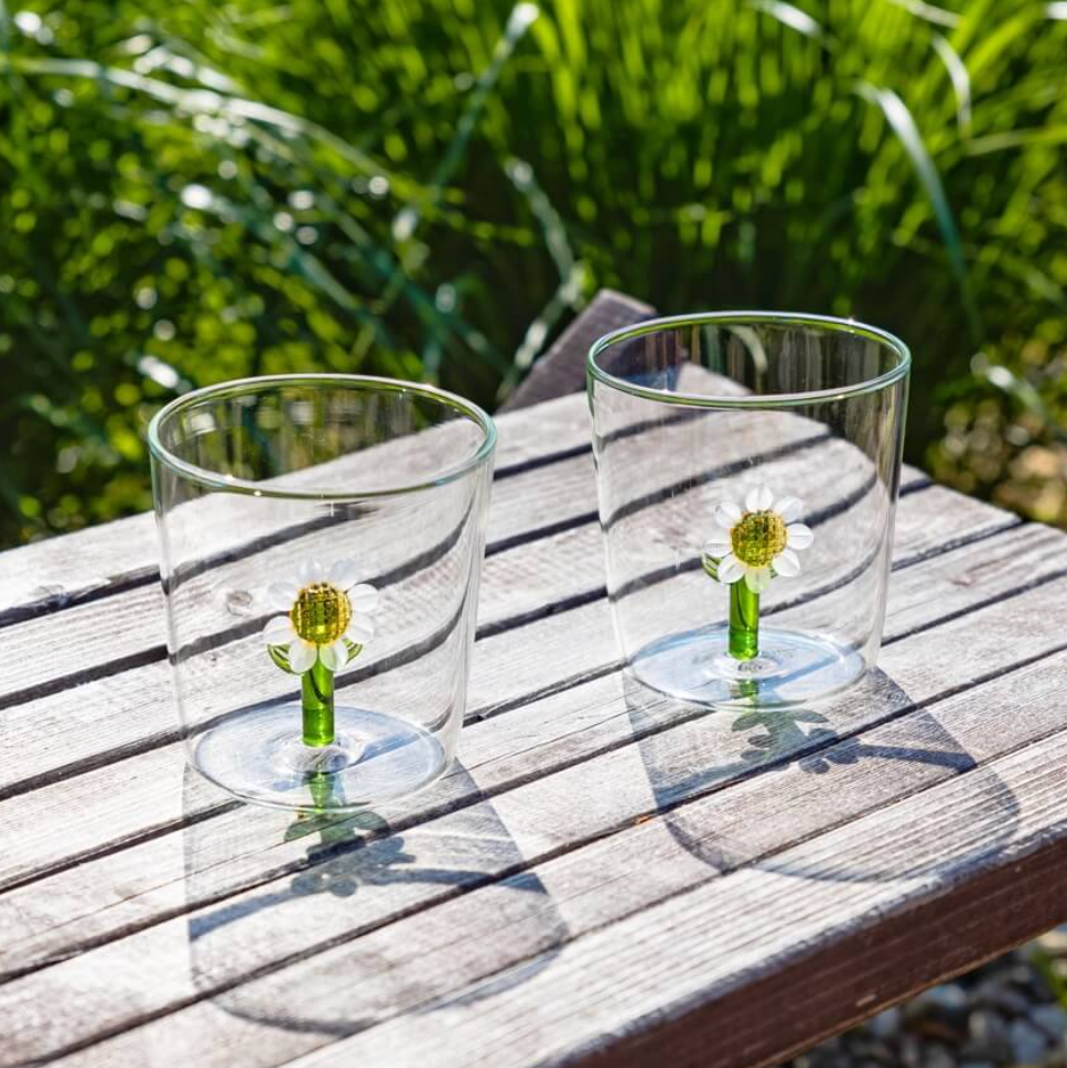 Close-up of the glass flower with gold centre and green leaves inside the tumbler