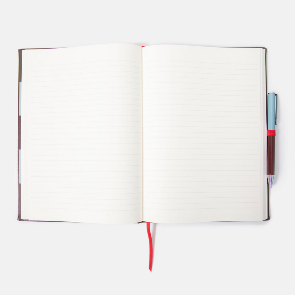 An open lined notebook with blank pages, a red bookmark ribbon, and a pen tucked on the right side, photographed on a clean white background.
