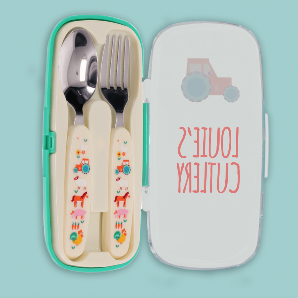 A children's cutlery set in a mint green plastic case, shown open with a spoon and fork inside. The handles are cream with colorful cartoon animal prints, and the lid is white with a pink tractor illustration and the words 'LOUIE'S CUTLERY' in pink.