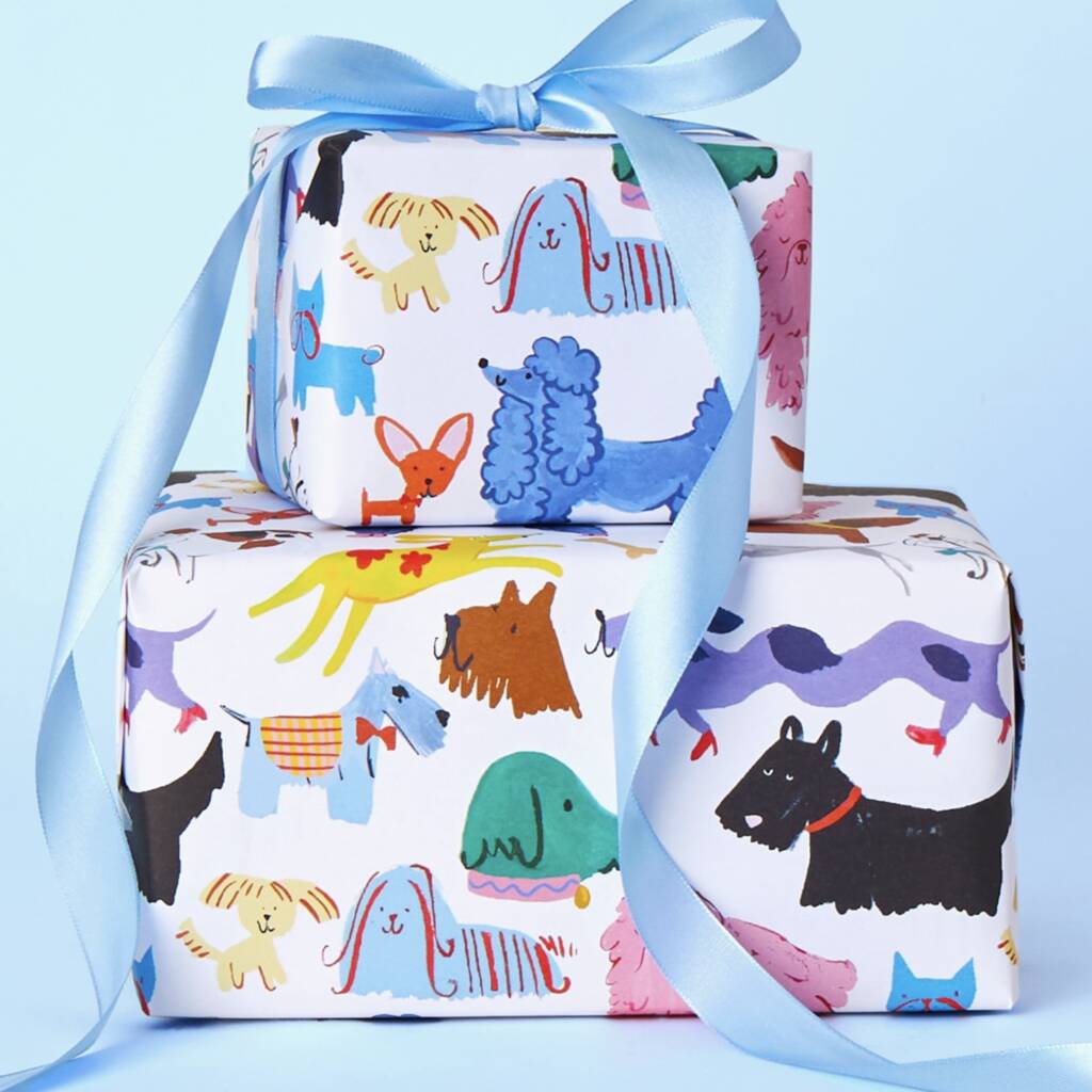 Two wrapped gift boxes stacked together with a light blue satin ribbon, featuring a colorful cartoon animal print on a white background, set against a solid light blue backdrop.