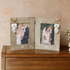 A rustic double-frame wedding photo frame set on a wooden cabinet against a textured beige wall. The frames are light beige wood with engraved 'MR' and 'MRS' at the bottom, decorated with small wooden hearts that read 'MR & MRS.